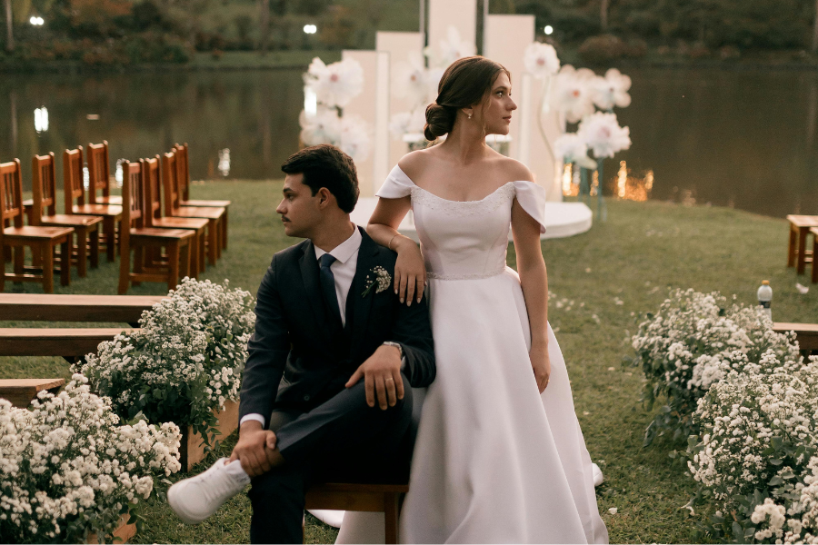 couples sitting on chair infront of a lake 