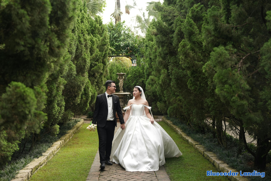 Bride and groom walking through a garden pathway after wedding ceremony