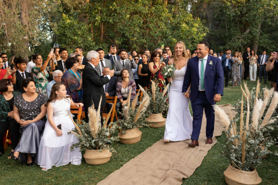 Fall Outdoor Wedding in Missouri: Weather, Sunset, and Backup Planning 2 Newlywed couple walking down the aisle after an outdoor wedding ceremony with guests