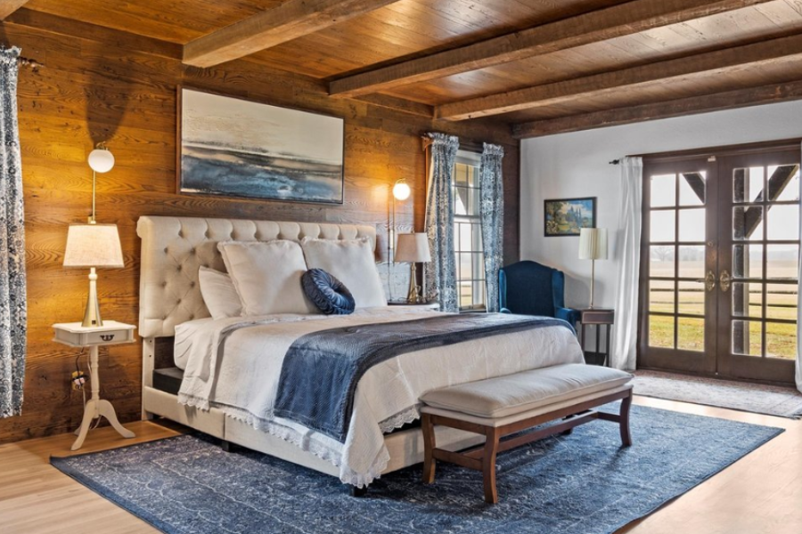 bedroom with warm lighting, wooden flooring and blue carpet 